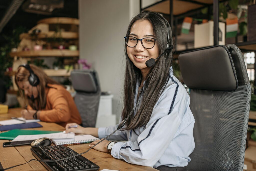 Customer support representative working in a modern office environment, providing assistance.